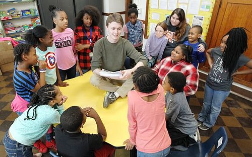 K student encircled by 15 Woodward Elementary schoolchildren
